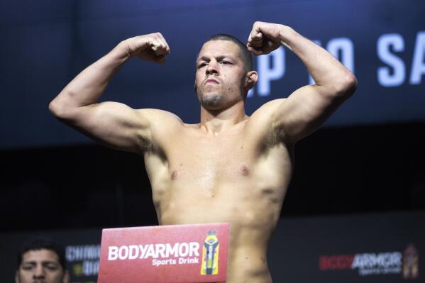 FILE -FILE - Welterweight fighter Nate Diaz poses on the scale during a ceremonial weigh-in for the UFC 279 mixed martial arts event on Sept. 9, 2022, in Las Vegas. Mixed martial arts fighter Nate Diaz turned himself in to police in New Orleans on Thursday, April 27, 2023, to face a battery charge arising from a weekend street brawl. (Steve Marcus/Las Vegas Sun via AP, File)