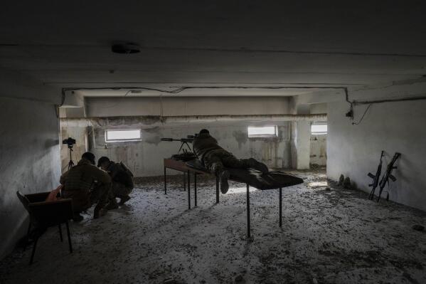 A sniper unit aims towards Russian positions during an operation, Kherson region, southern Ukraine, Saturday, Nov. 19, 2022. The Ukrainian sniper adjusted his scope, fired a.50-caliber bullet and said he saw a Russian soldier fall across the Dnieper River. Another Ukrainian used a drone to scan for Russian troops. Two weeks after retreating from from the southern city of Kherson, Russia is pounding the territory across the Dnieper with artillery. (AP Photo/Bernat Armangue, File)