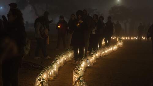 Personas caminan con velas a medianoche en el 50o aniversario del golpe de Estado de 1973, a las afueras del Palacio Legislativo en Montevideo, Uruguay, el martes 27 de junio de 2023. (AP Foto/Matilde Campodónico)