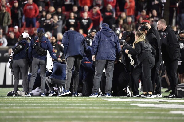 Louisville and Virginia Medical Staff surround Virginia running back Perris Jones following his injury during the second half of an NCAA college football game against Louisville in Louisville, Ky., Thursday, Nov. 9, 2023. (AP Photo/Timothy D. Easley)