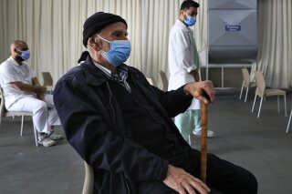A man waits his turn to receive the Pfizer-BioNTech COVID-19 vaccine during a nationwide vaccination campaign, at the Saint George Hospital, in Beirut, Lebanon, Tuesday, Feb. 16, 2021. Lebanon launched its inoculation campaign after receiving the first batch of the vaccine — 28,500 doses from Brussels with more expected to arrive in the coming weeks. (AP Photo/Hussein Malla)