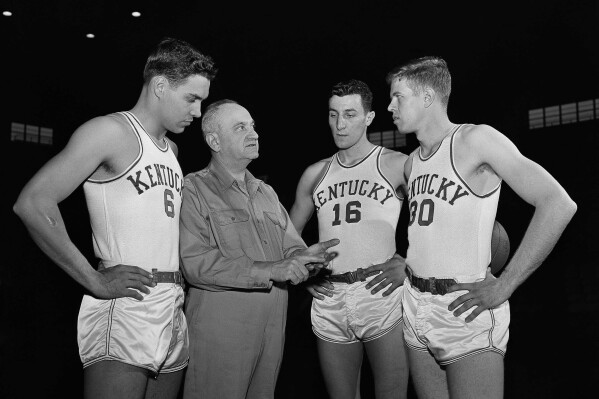 FILE - Kentucky basketball coach Adolph Rupp talks to players, from left, Cliff Hagan, Lou Tsioropoulos and Frank Ramsey (30) in Lexington, Ky., Jan. 16, 1954. (AP Photo/John Wyatt, File)