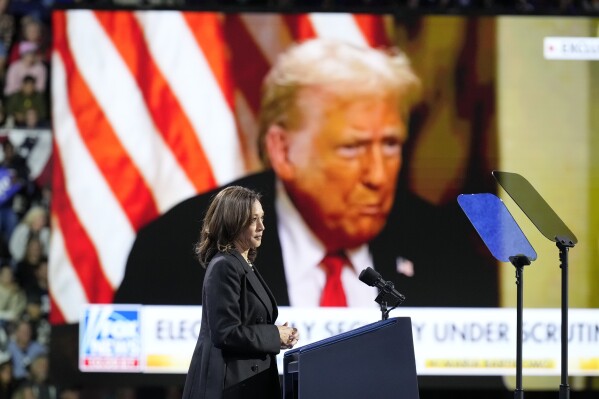 Democratic presidential nominee Vice President Kamala Harris speaks as an image of Republican presidential nominee former President Donald Trump appears on screen during a campaign rally at Erie Insurance Arena, in Erie, Pa., Monday, Oct. 14, 2024. (AP Photo/Jacquelyn Martin)