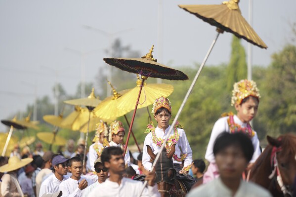 Would-be Buddhist novices ride on horses during a processional parade as part of a celebration of a novitiation or “Shinbyu,” ceremony, Saturday, March 15, 2025, at Hlegu township, outside of Yangon, Myanmar. (AP Photo/Thein Zaw)