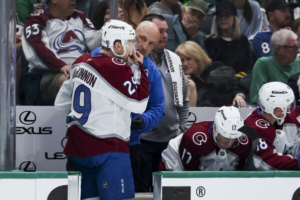 Colorado Avalanche center Nathan MacKinnon (29) is attended to by medical staff after he was high-sticked during a first-round NHL hockey playoff game against the Dallas Stars in Dallas, Saturday, April 19, 2025. (AP Photo/Gareth Patterson)