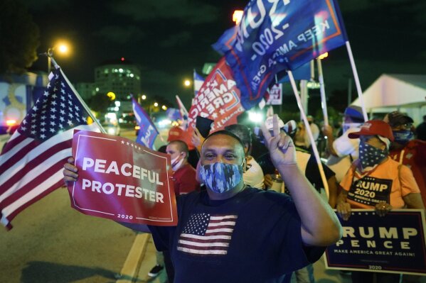 Supporters of President Donald Trump chant and wave flags outside the Versailles Cuban restaurant during an Election Night celebration, Tuesday, Nov. 3, 2020, in the Little Havana neighborhood of Miami. Trump and his Republican allies made significant inroads with Latino voters in Tuesday’s election, alarming some Democrats who warned that immigration politics alone was not enough to hold their edge with the nation’s largest minority group. (AP Photo/Wilfredo Lee)