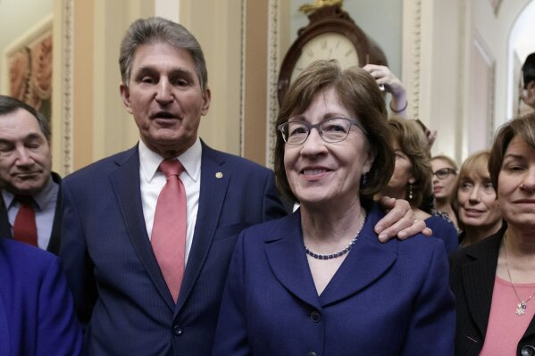 In this file photo from Monday, Jan. 22, 2018, Sen. Susan Collins, R-Maine, is joined by Sen. Joe Manchin, D-W.Va., left, and others as they celebrate the bipartisan effort to end a government shutdown, at the Capitol in Washington. Collins, a moderate Republican, is joining Manchin, a moderate Democrat, in opposition to confirming Neera Tanden, President Joe Biden's nominee for budget director. (AP Photo/J. Scott Applewhite, file)