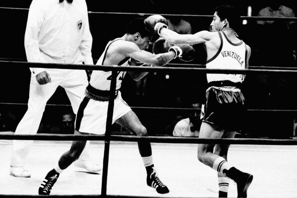 FILE - Francisco Rodriguez of Venezuela, right, throws a left to the head of Harland Marbley of the United States during their light heavyweight Olympic bout in Mexico City, Oct. 25, 1968. Rodriquez won on points. Francisco "Morochito" Rodríguez, who in 1968 won Venezuela's first gold medal at an Olympic Games when he won the light flyweight division, died on Wednesday, April 24, 2024. He was 78. (AP Photo, File)