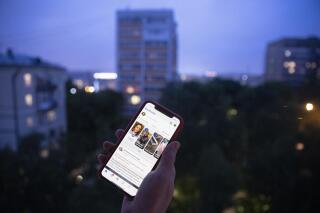 A user holds a smartphone with an opened Facebook page in Moscow, Russia, Thursday, June 10, 2021. Russian authorities have ordered Facebook and messaging app Telegram to pay steep fines for failing to remove banned content. The move could be part of growing Russian efforts to tighten control over social media platforms. A Moscow court fined Facebook a total of 17 million rubles (roughly $236,000) and Telegram 10 million rubles ($139,000). (AP Photo/Pavel Golovkin)