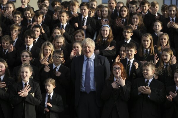 The Chulmleigh College school choir sings and signs 'A Lovely Day' as Britain's Prime Minister and Conservative Party leader, Boris Johnson visit in Chulmleigh, England, Thursday Nov. 28, 2019, ahead of the general election on Dec. 12. (Dan Kitwood/Pool via AP)