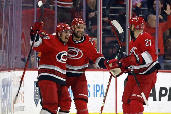 Carolina Hurricanes' Seth Jarvis, left, celebrates his hat trick goal with teammates Calvin de Haan, center, and Derek Stepan (21) during the third period of an NHL hockey game against the Montreal Canadiens in Raleigh, N.C., Thursday, Feb. 16, 2023. (AP Photo/Karl B DeBlaker)