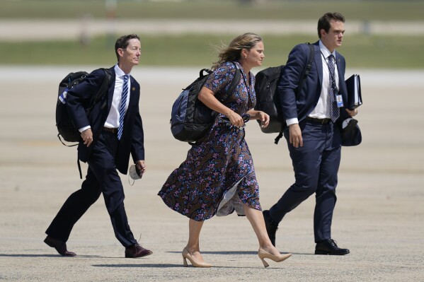 FILE - Bruce Reed, from left, Assistant to the President and Deputy Chief of Staff, Annie White House senior adviser and director of Oval Office Operations, and Jacob Spreyer board Air Force One behind President Joe Biden, Aug. 30, 2022, at Andrews Air Force Base, Md. Biden has chosen Tomasini to be a White House deputy chief of staff. (AP Photo/Patrick Semansky, File)