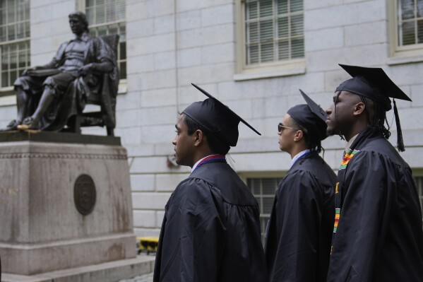 Graduating students walk through Harvard Yard during commencement ceremonies at Harvard University, Thursday, May 29, 2025, in Cambridge, Mass. (AP Photo/Charles Krupa)