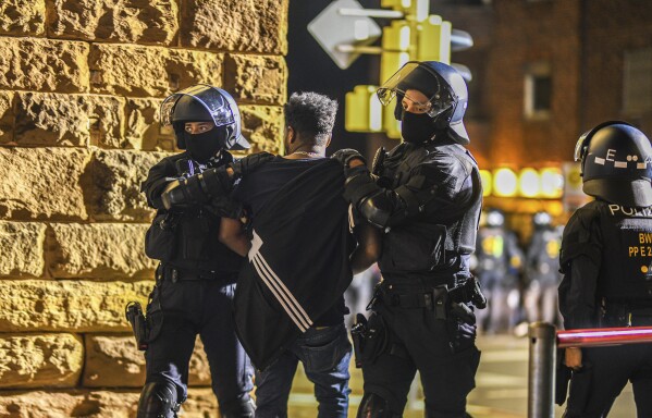A man is taken away by police officers in Stuttgart, Baden-Württemberg, Germany, on Saturday, Sept. 16, 2023, after clashes at a gathering of Eritrean groups. (Jason Tschepljakow/dpa via AP)