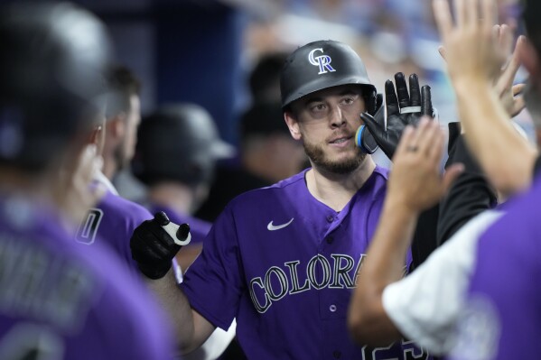 Colorado Rockies' C.J. Cron is congratulated by teammates after he hit a home run scoring Jurickson Profar, during the first inning of a baseball game against the Miami Marlins, Friday, July 21, 2023, in Miami. (AP Photo/Wilfredo Lee)