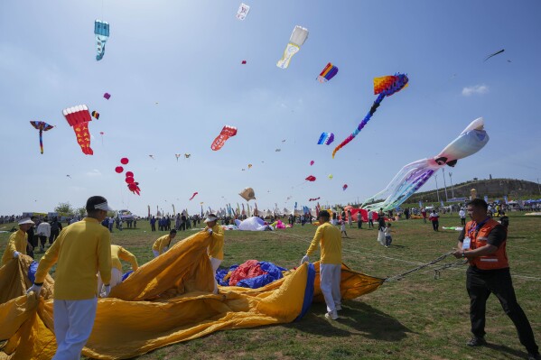 Participants prepare a kite during the 41st International Kite Festival in Weifang, Shandong Province of China, Saturday, April 20, 2024. (AP Photo/Tatan Syuflana)
