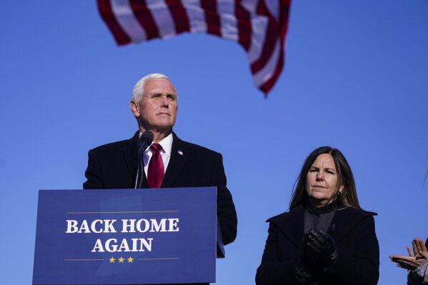 FILE - In this Jan. 20, 2021, file photo, former Vice President Mike Pence speaks after arriving back in his hometown of Columbus, Ind., as his wife Karen watches. Less than three months after former President Donald Trump left the White House, the race to succeed him is already beginning. Pence has started a political advocacy group, finalized a book deal and later this month in South Carolina will give his first speech since leaving office.  (AP Photo/Michael Conroy, File)