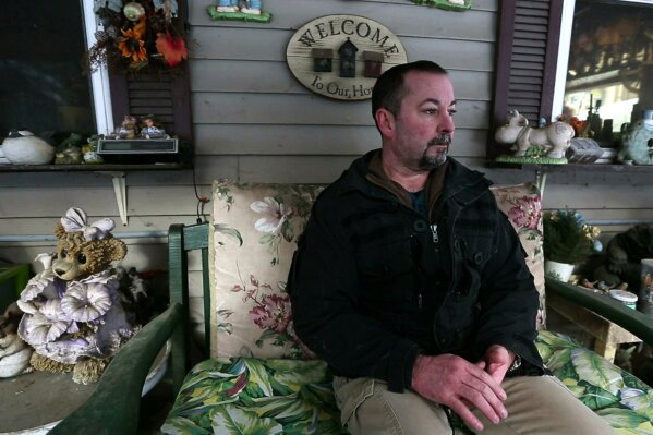 
              In this Thursday, March 7, 2019 photo, former SWAT officer Al Joyce sits on the porch at his mother's home in Otisfield, Maine. Joyce left his job in law enforcement in Jefferson County, Colorado, after a school shooting and now works as a cashier. Joyce was part of the team that in 2006 stormed a classroom in Platte Canyon High School in the town of Bailey, southwest of Denver and saw the aftermath of a shooting. It wasn't long before the nightmares began and he started drinking heavily to avoid them. He ended up leaving the SWAT team, divorcing his wife and withdrawing from the world. "I wanted to just shut down, turn off," he said. "It didn't work out so well."(AP Photo/Robert F. Bukaty)
            