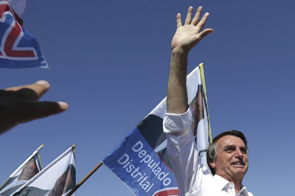 
              FILE - In this Sept. 5, 2018 file photo,  presidential candidate Jair Bolsonaro greets supporters during a campaign rally in Brasilia's Ceilandia neighborhood, Brazil.  Few people in Brazil other than Bolsonaro’s most ardent supporters believed the far-right congressman had more than an outside shot of winning the Oct. 28, 2018 presidential race to lead Latin America's largest nation. (AP Photo/Eraldo Peres, File)
            
