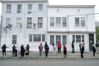 People wait in line for food assistance due to the coronavirus pandemic in Paterson, N.J., Wednesday, April 29, 2020. (AP Photo/Seth Wenig)