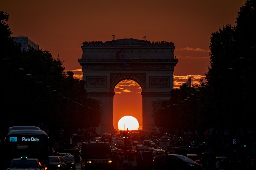 The setting sun, framed by the Arc de Triomphe, illuminates the Champs-Élysées during the 2024 Summer Olympics, Friday, Aug. 2, 2024, in Paris, France. (AP Photo/Vadim Ghirda)
