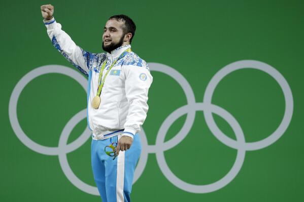 FILE - Nijat Rahimov, of Kazakhstan, acknowledges the applause after receiving his gold medal for the men's 77kg weightlifting competition at the 2016 Summer Olympics in Rio de Janeiro, Brazil, Aug. 10, 2016. Rahimov has been stripped of his 2016 title for doping and banned for eight years, it was announced Tuesday, March 22 2022. The Court of Arbitration for Sport says the Kazakh lifter was guilty of “four urine substitutions.” (AP Photo/Mike Groll, file)