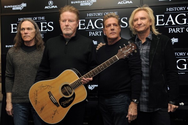 FILE - Members of The Eagles, from left, Timothy B. Schmit, Don Henley, Glenn Frey and Joe Walsh pose with an autographed guitar after a news conference at the Sundance Film Festival, in Park City, Utah, Jan. 19, 2013. Henley, the co-founder of classic rock band the Eagles, is scheduled to testify Monday, Feb. 26, 2024, at the criminal trial of three collectibles professionals. They're charged with colluding to veil the questioned ownership of sheets of draft lyrics to 鈥淗otel California鈥� and other Eagles hits in order to sell them and deflect Henley鈥檚 demands for their return. (Photo by Chris Pizzello/Invision/AP, File)