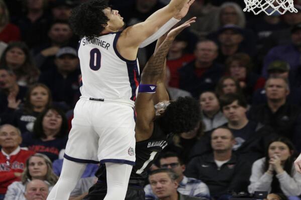 Gonzaga guard Julian Strawther (0) shoots while defended by Washington forward Keion Brooks (1) during the first half of an NCAA college basketball game, Friday, Dec. 9, 2022, in Spokane, Wash. (AP Photo/Young Kwak)