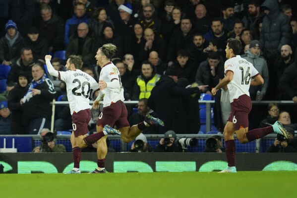 Manchester City's Bernardo Silva, left, celebrates after scoring his sides third goal during the English Premier League soccer match between Everton and Manchester City at Goodison Park stadium in Liverpool, England, Wednesday, Dec. 27, 2023. (AP Photo/Jon Super)