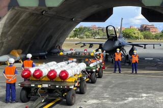 Archivo - Personal militar junto al Harpoon A-84 de Estados Unidos, misiles antibuques y misiles aire-aire AIM-120 y AIM-9 preparados para ejercicios de carga de armas frente a un avión de combate F-16V de Estados Unidos en la base aérea de Hualien, Taiwán, el 17 de agosto de 2022. (AP Foto/Johnson Lai, Archivo)