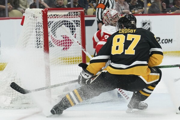 Pittsburgh Penguins' Sidney Crosby (87) scores against Detroit Red Wings goaltender Alex Lyon, left, during the second period of an NHL hockey game, Thursday, April 11, 2024, in Pittsburgh. (AP Photo/Matt Freed)