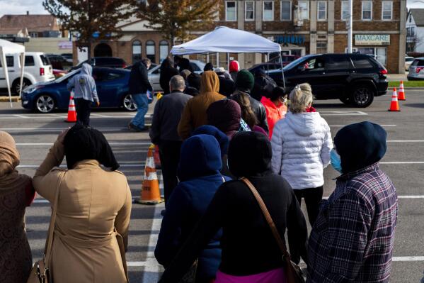 FILE - Hundreds of Hamtramck residents wait in line to receive water filters and cases of water bottles on Oct. 26, 2021, in Hamtramck, Mich. Water systems occasionally produce elevated test results and the state is tracking a handful of areas like Hamtramck with high levels. But in Benton Harbor, officials haven't been able to bring the results back down. (Nicole Hester/MLIVE.com/The Grand Rapids Press via AP, File)