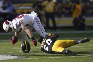 Pittsburgh Steelers linebacker Elandon Roberts (50) loses his helmet as he tackles Arizona Cardinals tight end Trey McBride, left, during the first half of an NFL football game Sunday, Dec. 3, 2023, in Pittsburgh. (APPhoto/Matt Freed)