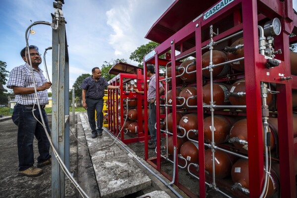 P V R Murthy, center, general manager at Oil India Limited, pump station 3, shows a part of a hydrogen plant in Jorhat, India, Thursday, Aug. 17, 2023. Green hydrogen is being touted around the world as a clean energy solution to take the carbon out of high-emitting sectors like transport and industrial manufacturing. (AP Photo/Anupam Nath)