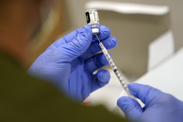 FILE - A healthcare worker fills a syringe with the Pfizer COVID-19 vaccine at Jackson Memorial Hospital, Oct. 5, 2021, in Miami. Three years after COVID-19 vaccines became widely available in the United States, Louisiana continues to debate policies related to inoculation mandates, including civil labilities if a work place mandates vaccines or not and a bill that would prohibit schools from requiring students to receive the vaccine. (AP Photo/Lynne Sladky, File)