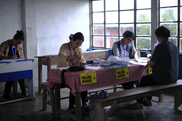 Polling officers, left to right, Dekule Kapfo, 34, Neke W Konyak, 29, Neichutuonuo Yhome, 27, and Nukutholu Nienu, 44, prepare election related paperwork on the eve of polling in Chedema village, in the northeastern Indian state of Nagaland, Thursday, April 18, 2024. (AP Photo/Yirmiyan Arthur)