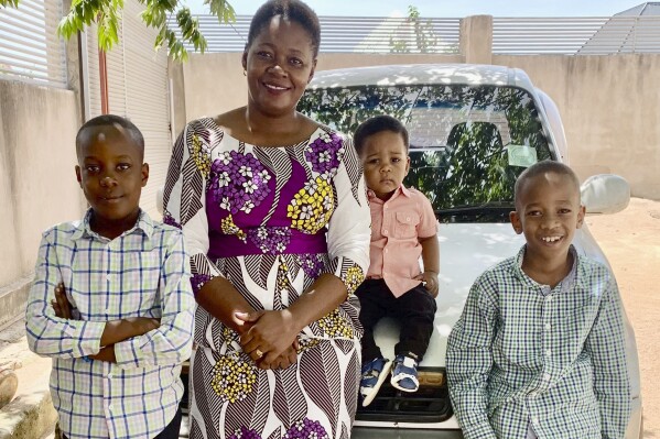 This family photo shows Pascazia Mazeze, executive director of the Tanzania Sickle Cell Warriors Organization, with her sons, from left, Ian, Rian and Gian outside their home in Tanzania on April 9, 2023. Ian, who has sickle cell disease, takes hydroxyurea and folic acid for anemia. They’ve helped, but haven’t eliminated pain episodes like the one that put him in the hospital for two weeks in 2023. (Courtesy Pascazia Mazeze via AP)
