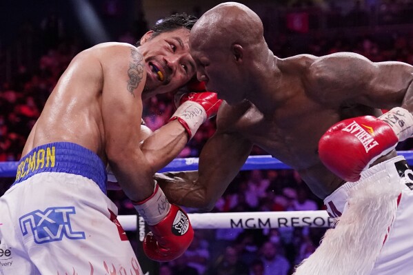 Yordenis Ugas, right, of Cuba, punches Manny Pacquiao, of the Philippines, during a welterweight championship boxing match Saturday, Aug. 21, 2021, in Las Vegas. (AP Photo/John Locher, File)