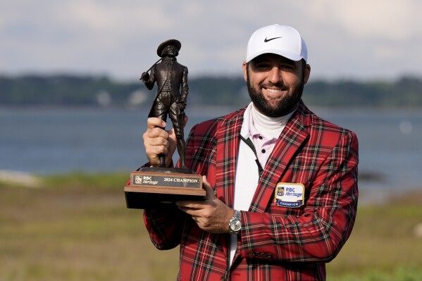 Scottie Scheffler holds the trophy after winning the weather delayed RBC Heritage golf tournament, Monday, April 22, 2024, in Hilton Head Island, S.C. (AP Photo/Chris Carlson)