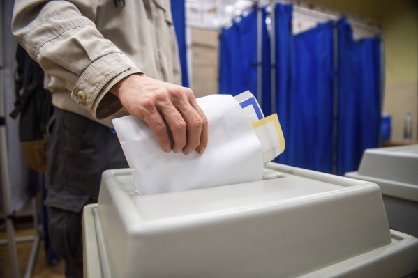 A man votes at a polling station during the European Parliament and the local elections in Budapest, Hungary, Sunday, June 9, 2024. (Zoltan Balogh/MTI via AP)