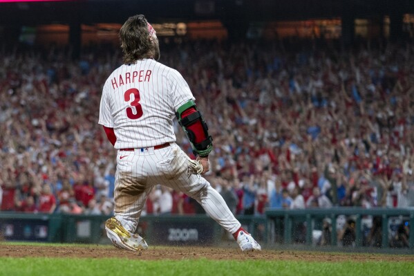 Philadelphia Phillies' Bryce Harper reacts after scoring against the Miami Marlins during the eighth inning of Game 1 in an NL wild-card baseball playoff series Tuesday, Oct. 3, 2023, in Philadelphia. The Phillies won 4-1. (AP Photo/Chris Szagola)