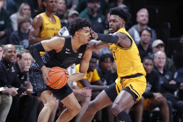 Michigan State's Jaden Akins, left, is guarded by Oakland's Rocket Watts during the first half of an NCAA college basketball game, Wednesday, Dec. 21, 2022, in East Lansing, Mich. (AP Photo/Al Goldis)