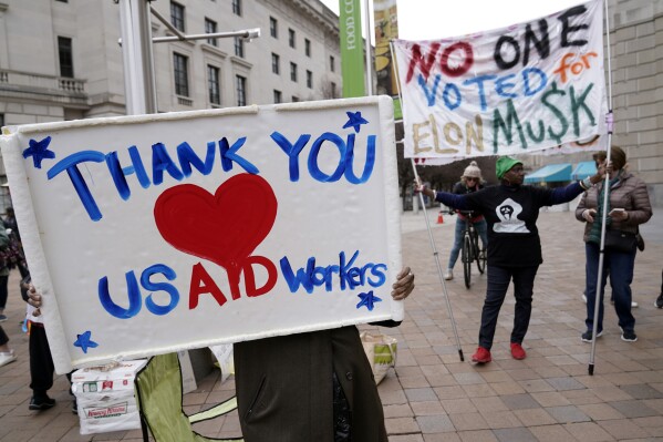 Supporters cheers the United States Agency for International Development (USAID) workers, as they carry their personal belongings after retrieving them from the USAID&#x27;s headquarters in Washington, Thursday, Feb. 27, 2025. (AP Photo/Jose Luis Magana, File)