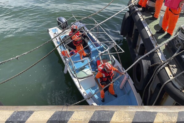 In this photo released by the Taiwan Coast Guard, Taiwan's coast guard officials are seen on board a speedboat that an alleged former Chinese naval officer used to enter a harbor in New Taipei city, Taiwan on Monday, June 10, 2024. Taiwanese authorities are investigating how the Chinese man had driven the small boat into a strategic river mouth that leads to the capital of the self-governing island republic. (Taiwan Coast Guard via AP)