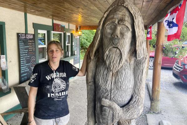 Pauline Bauer leans against a wooden statue outside Bob's Trading Post, her restaurant in Hamilton, Pa., July 21, 2021. A federal judge has convicted a Bauer of storming the U.S. Capitol, where she screamed at police officers to bring out then-House Speaker Nancy Pelosi so the pro-Trump mob could hang her. (AP Photo/Michael Kunzelman)