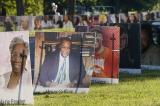 FILE - In this Monday, Aug. 31, 2020 file photo, some of the nearly 900 large poster-sized photos of Detroit victims of COVID-19 are displayed on Belle Isle in Detroit. The COVID-19 pandemic pushed total U.S. deaths last year beyond 3.3 million, the nation’s highest-ever annual death toll, the government reported Wednesday, March 31, 2021. (AP Photo/Carlos Osorio)