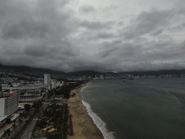 Acapulco Bay is void of boats while they are stored on shore as the nearby passing of Hurricane Erick brings dark clouds, Thursday, June 19, 2025. (AP Photo/Fernando Llano)
