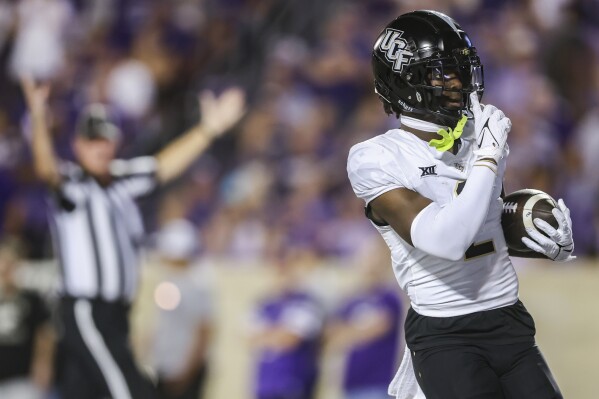 Central Florida wide receiver Kobe Hudson quiets the Kansas State crowd after scoring a touchdown on a trick play during the first half of an NCAA college football game on Saturday, Sept. 23, 2023, in Manhattan, Kan. (AP Photo/Travis Heying)
