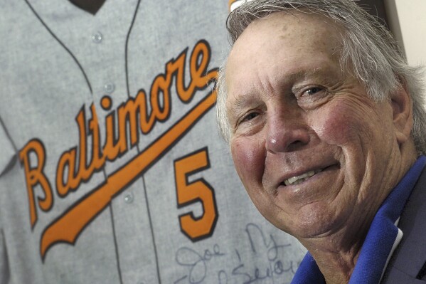 FILE - Baseball Hall of Fame third baseman Brooks Robinson, who played 23 years for the Baltimore Orioles, stands near a vintage jersey June 12, 2007, at his office in Ellicott City, Md. Robinson, whose deft glovework and folksy manner made him one of the most beloved and accomplished athletes in Baltimore history, has died. He was 86. The Orioles announced his death in a joint statement with Robinson's family Tuesday, Sept. 26, 2023. The statement did not say how Robinson died. (AP Photo/Steve Ruark, File)