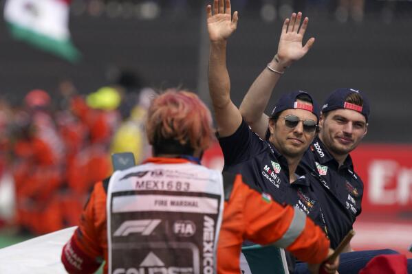 Red Bull driver Max Verstappen, of the Netherlands, right, and teammate Sergio Perez, of Mexico, wave to the crowd during a parade prior to the Formula One Mexico Grand Prix auto race at the Hermanos Rodriguez racetrack in Mexico City, Sunday, Oct. 30, 2022. (AP Photo/Fernando Llano)